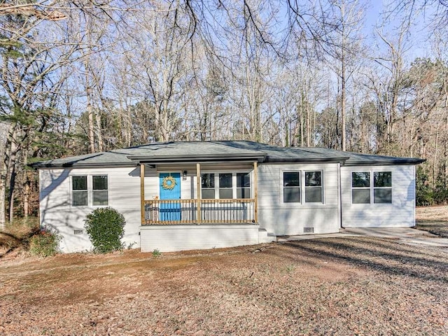 ranch-style home with a shingled roof, covered porch, and crawl space