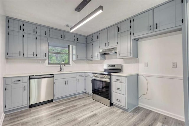 2931 Randolph Ct, Conyers, GA 30012 - kitchen with stainless steel appliances, under cabinet range hood, light wood finished floors, light countertops, and a sink