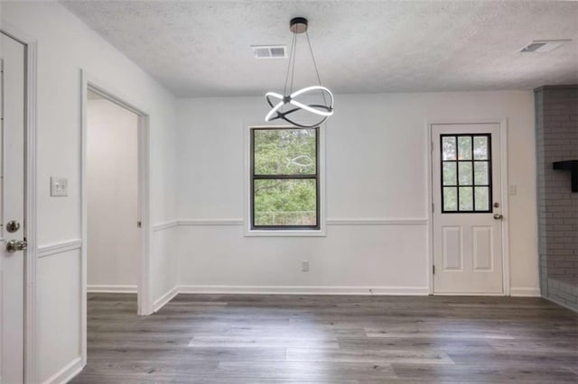 2931 Randolph Ct, Conyers, GA 30012 - unfurnished dining area with a textured ceiling, wood finished floors, a chandelier, and baseboards