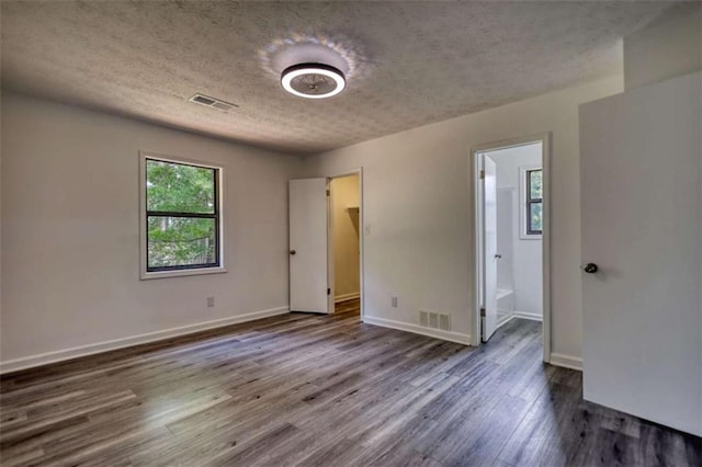 2931 Randolph Ct, Conyers, GA 30012 - unfurnished bedroom featuring a textured ceiling, dark wood-type flooring, baseboards, and ensuite bath