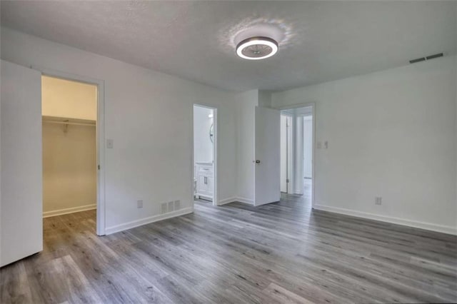 2931 Randolph Ct, Conyers, GA 30012 - unfurnished bedroom featuring a walk in closet, wood finished floors, and baseboards