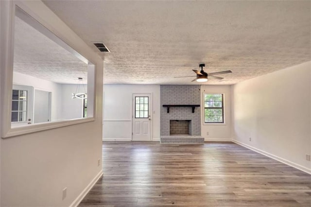 2931 Randolph Ct, Conyers, GA 30012 - unfurnished living room with a ceiling fan, wood finished floors, a textured ceiling, a fireplace, and baseboards