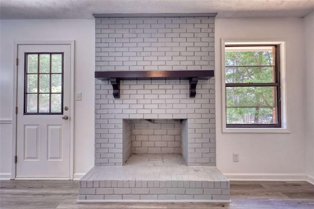 2931 Randolph Ct, Conyers, GA 30012 - detailed view of wood finished floors, a textured ceiling, baseboards, and a brick fireplace