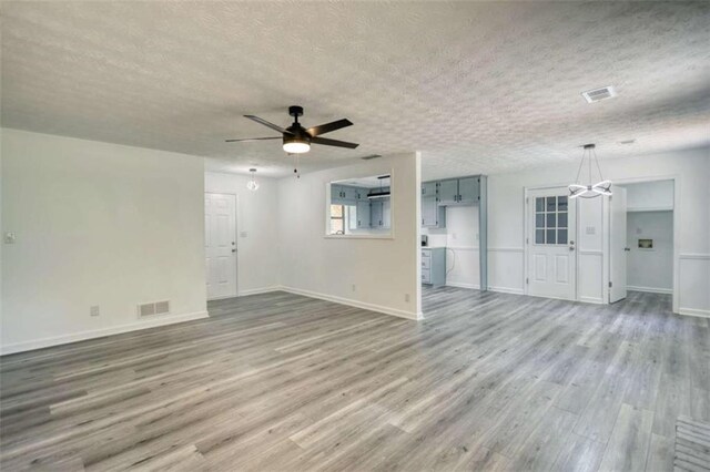 2931 Randolph Ct, Conyers, GA 30012 - unfurnished living room with a textured ceiling, wood finished floors, ceiling fan, a chandelier, and baseboards