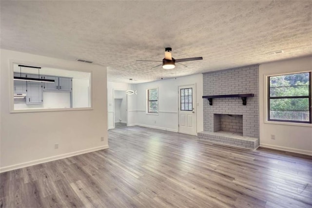 2931 Randolph Ct, Conyers, GA 30012 - unfurnished living room with ceiling fan, healthy amount of natural light, baseboards, wood finished floors, and a textured ceiling