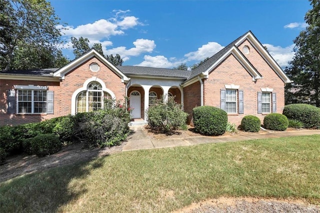 ranch-style house featuring brick siding and a front yard