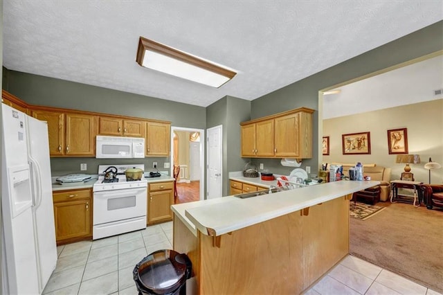 kitchen with a kitchen breakfast bar, open floor plan, white appliances, a peninsula, and light tile patterned floors