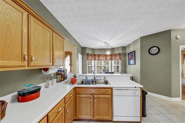 kitchen featuring light tile patterned floors, a peninsula, a sink, light countertops, and dishwasher