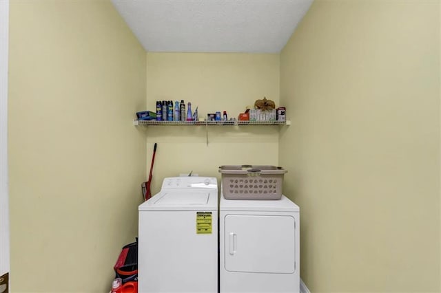 laundry room featuring a textured ceiling, laundry area, and washing machine and clothes dryer