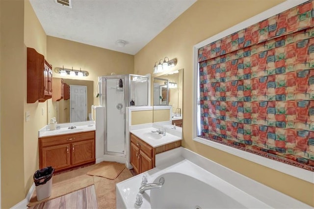 full bathroom with a sink, a textured ceiling, a bath, and a shower stall