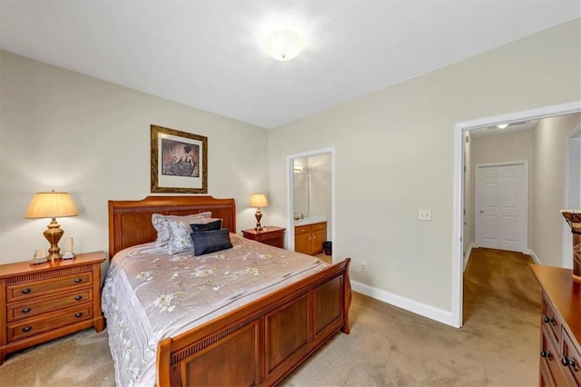 bedroom featuring light colored carpet, ensuite bath, and baseboards