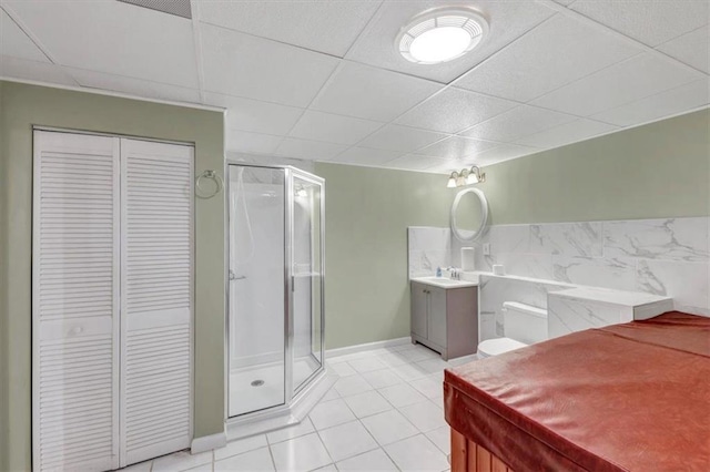 bathroom featuring tile patterned flooring, a shower stall, vanity, and a closet