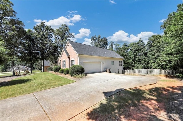 view of property exterior featuring a yard, fence, a garage, and driveway