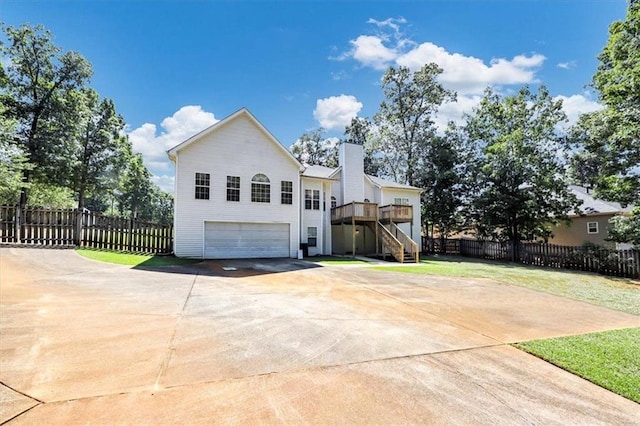 view of front of home featuring a front yard, stairway, an attached garage, and fence