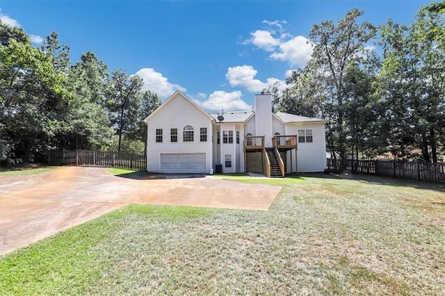 rear view of property with fence, a yard, stairs, concrete driveway, and a garage