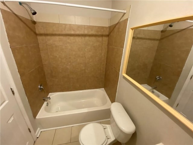 bathroom featuring toilet, tiled shower / bath combo, and tile patterned flooring