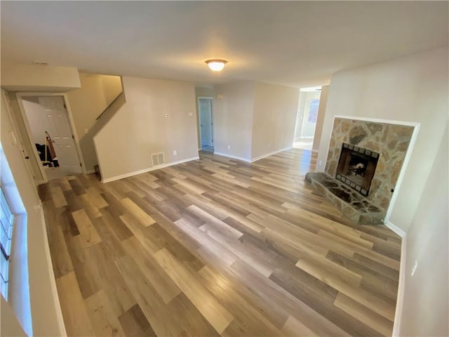 unfurnished living room featuring a fireplace and wood-type flooring