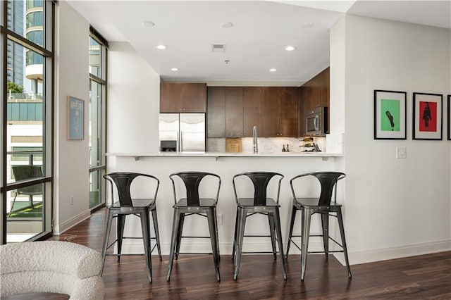 905 Juniper St NE Unit 805, Atlanta, GA 30309 - kitchen featuring appliances with stainless steel finishes, light countertops, a peninsula, backsplash, and recessed lighting