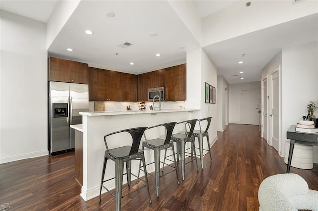 905 Juniper St NE Unit 805, Atlanta, GA 30309 - kitchen featuring appliances with stainless steel finishes, light countertops, a peninsula, a breakfast bar, and recessed lighting