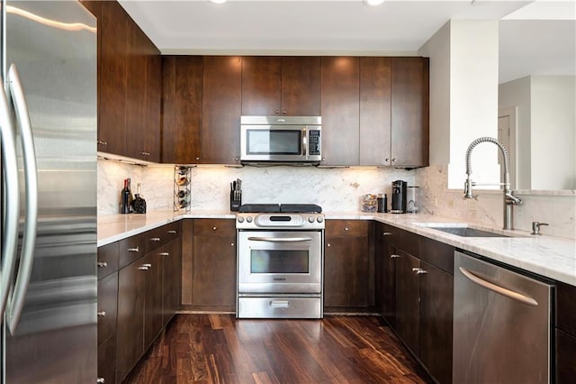 905 Juniper St NE Unit 805, Atlanta, GA 30309 - kitchen featuring appliances with stainless steel finishes, dark wood-type flooring, light stone countertops, dark brown cabinetry, and tasteful backsplash