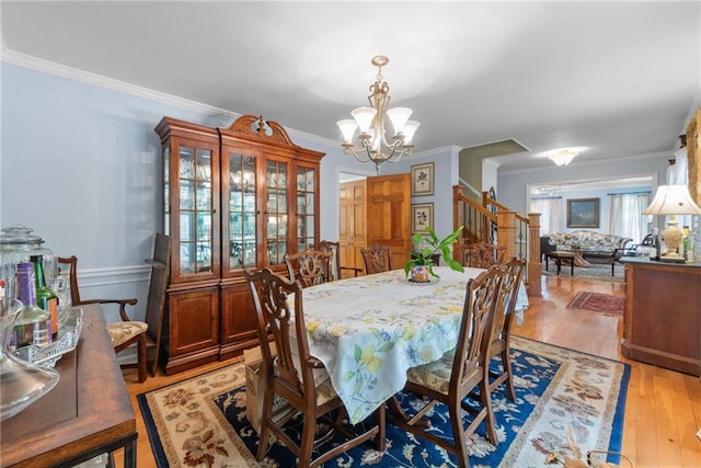 dining room featuring light hardwood / wood-style flooring, ornamental molding, and a notable chandelier