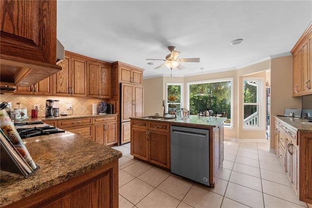 kitchen featuring appliances with stainless steel finishes, ornamental molding, a kitchen island with sink, ceiling fan, and light tile patterned floors