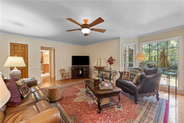 living room featuring light hardwood / wood-style floors, ceiling fan, and ornamental molding