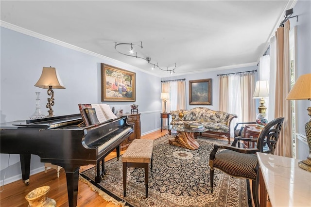 interior space with hardwood / wood-style flooring, track lighting, and ornamental molding