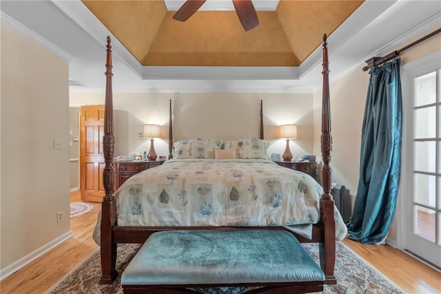 bedroom with a tray ceiling, crown molding, and light hardwood / wood-style flooring