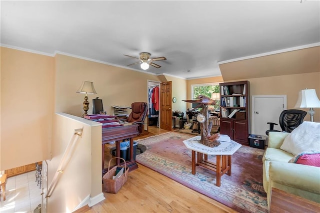 living room with ceiling fan, ornamental molding, and light wood-type flooring