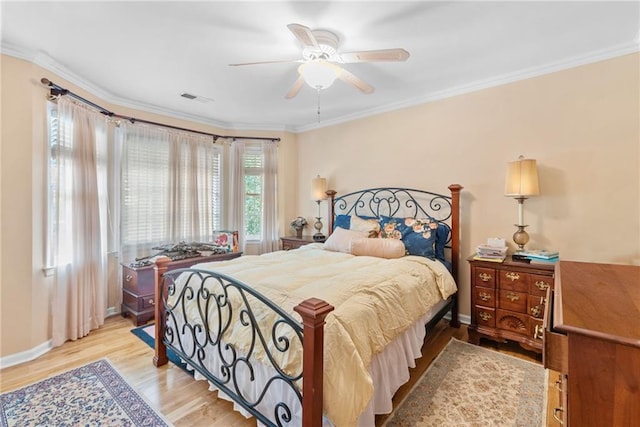 bedroom featuring ceiling fan, crown molding, and light wood-type flooring