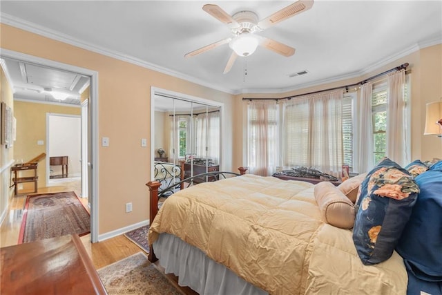 bedroom with ceiling fan, a closet, wood-type flooring, and ornamental molding