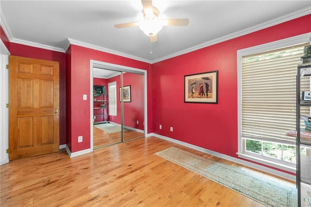 unfurnished bedroom featuring ceiling fan, ornamental molding, light hardwood / wood-style flooring, and a closet