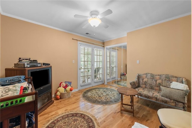 living room with ceiling fan, hardwood / wood-style floors, and ornamental molding