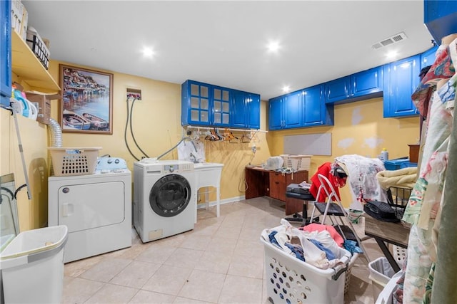 laundry area with light tile patterned floors and washing machine and clothes dryer