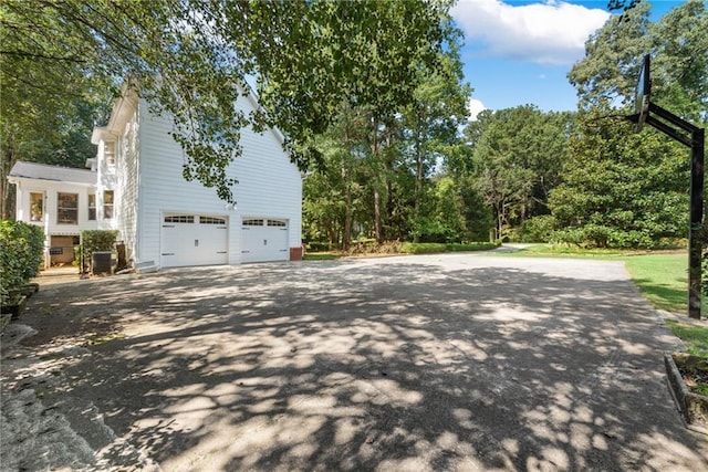 view of side of property featuring a garage and cooling unit