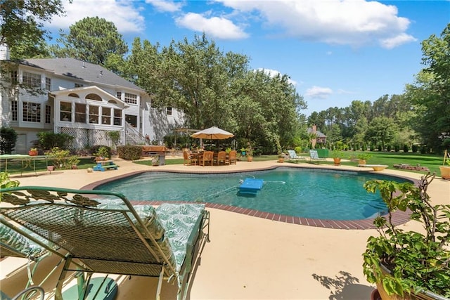 view of pool featuring a diving board, a patio area, and a sunroom