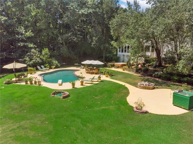 view of swimming pool with a patio area, a yard, and an outdoor fire pit