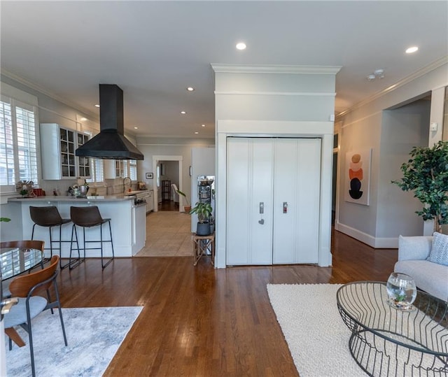 living room with tile patterned floors, sink, and ornamental molding