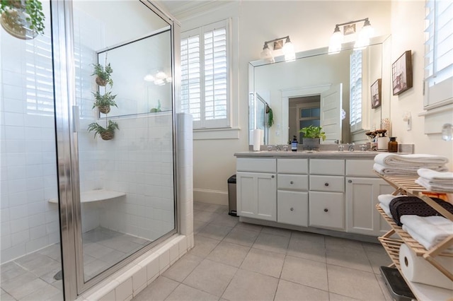 bathroom featuring a healthy amount of sunlight, tile patterned flooring, an enclosed shower, and dual bowl vanity