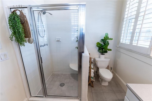 bathroom featuring vanity, a shower with shower door, toilet, and tile patterned flooring