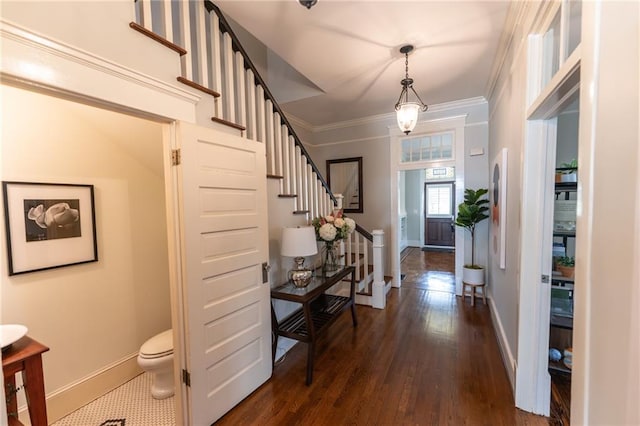 entrance foyer with dark wood-type flooring and crown molding