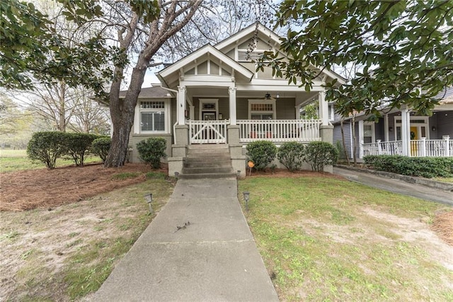 view of front of house with a porch, ceiling fan, and a front lawn