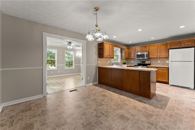 241 Cook St, Alto, GA 30510 - kitchen featuring stainless steel appliances, baseboards, a chandelier, decorative backsplash, and brown cabinets