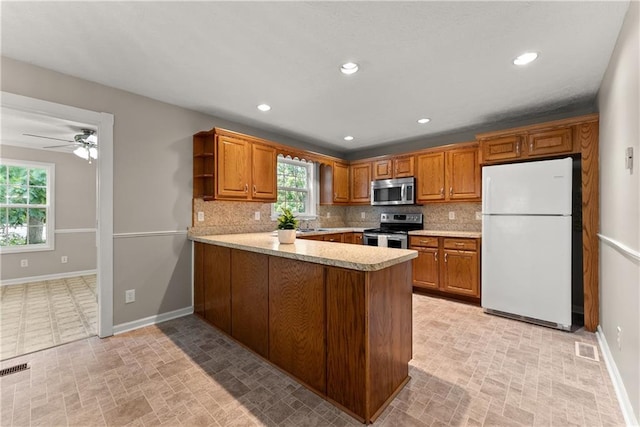 241 Cook St, Alto, GA 30510 - kitchen featuring appliances with stainless steel finishes, baseboards, a peninsula, brown cabinetry, and recessed lighting