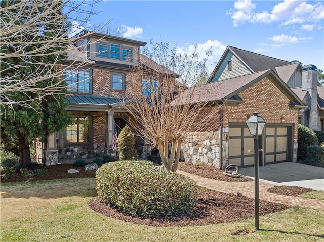 exterior space with an attached garage, stone siding, brick siding, concrete driveway, and a lawn