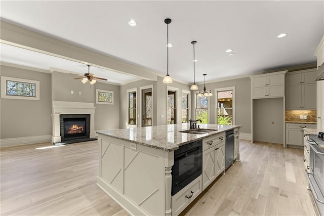 kitchen featuring black microwave, baseboards, crown molding, and a sink