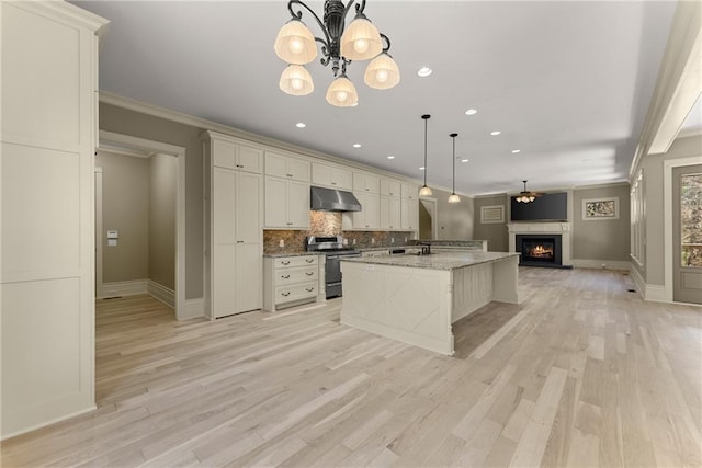 kitchen featuring electric range, backsplash, open floor plan, baseboards, and under cabinet range hood