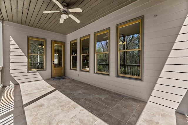 unfurnished sunroom with a ceiling fan