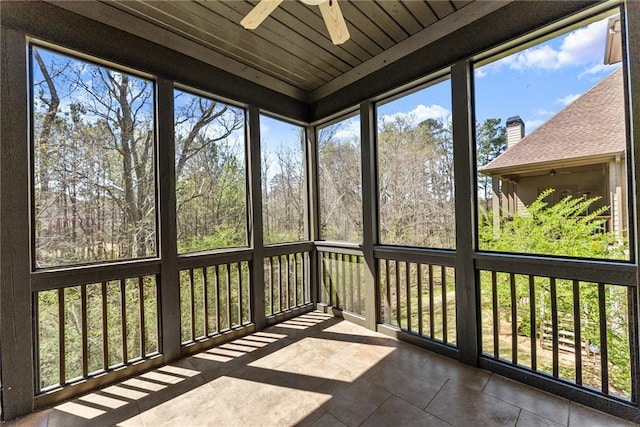 unfurnished sunroom featuring ceiling fan